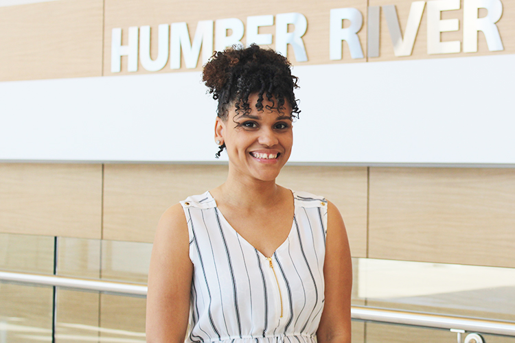 Massiel smiles at the camera in front of the Humber River Hospital sign.