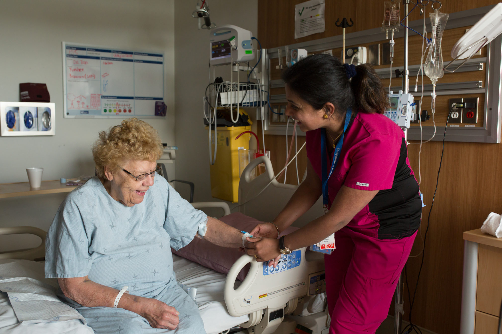 a nurse helps a senior patient out of bed