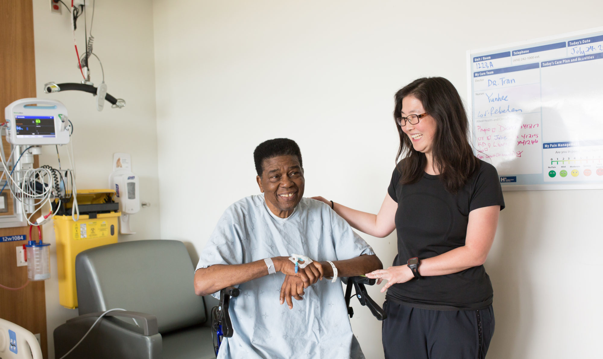 A physiotherapist pats a senior patient on the back