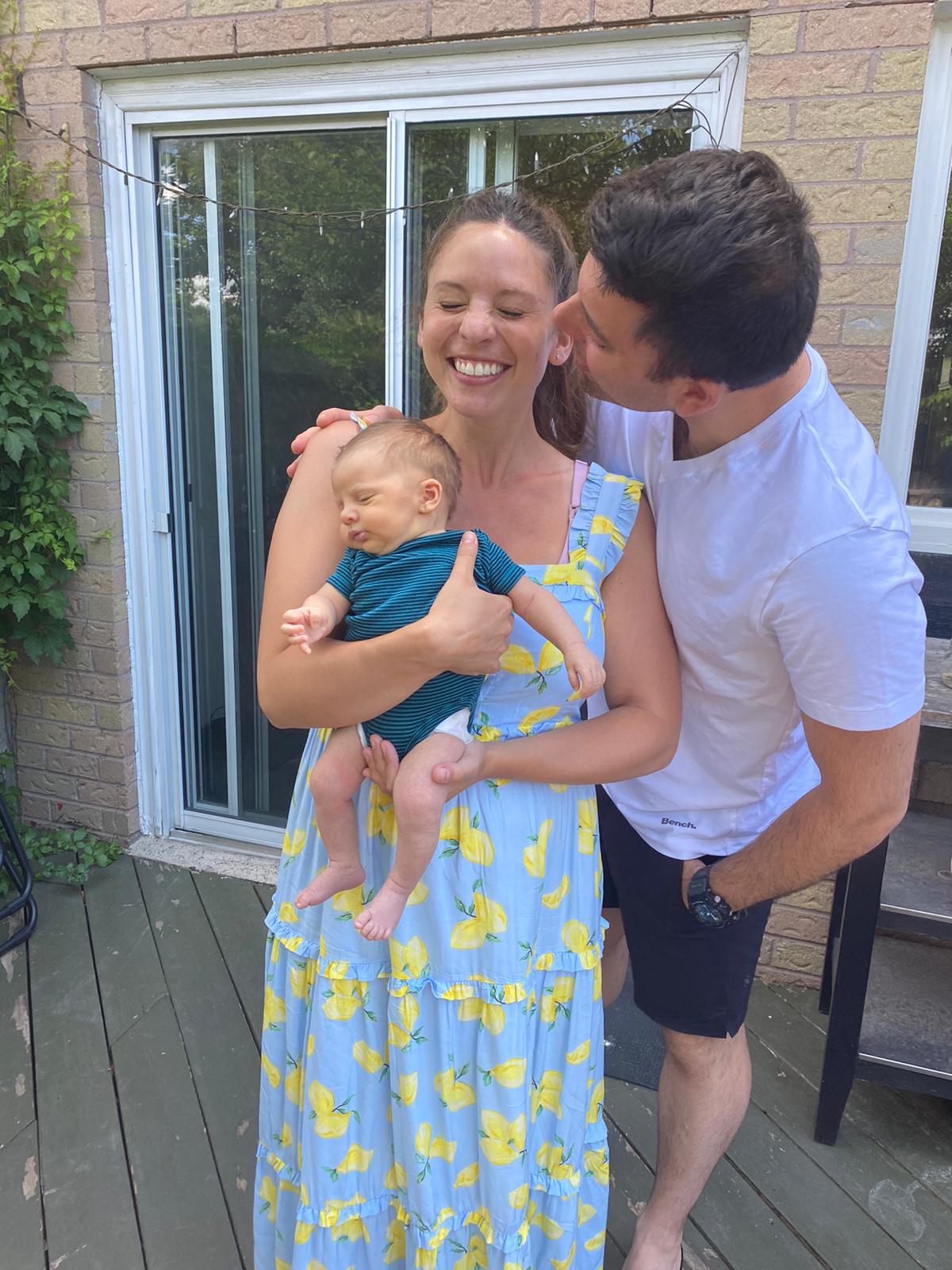 Rebecca Holds Zoey while David Kisses her on the cheek