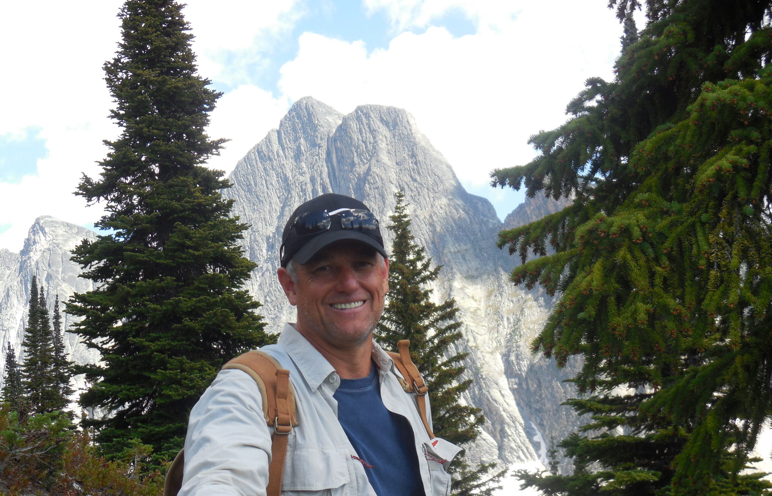 Another photo of John smiling in front of a mountain