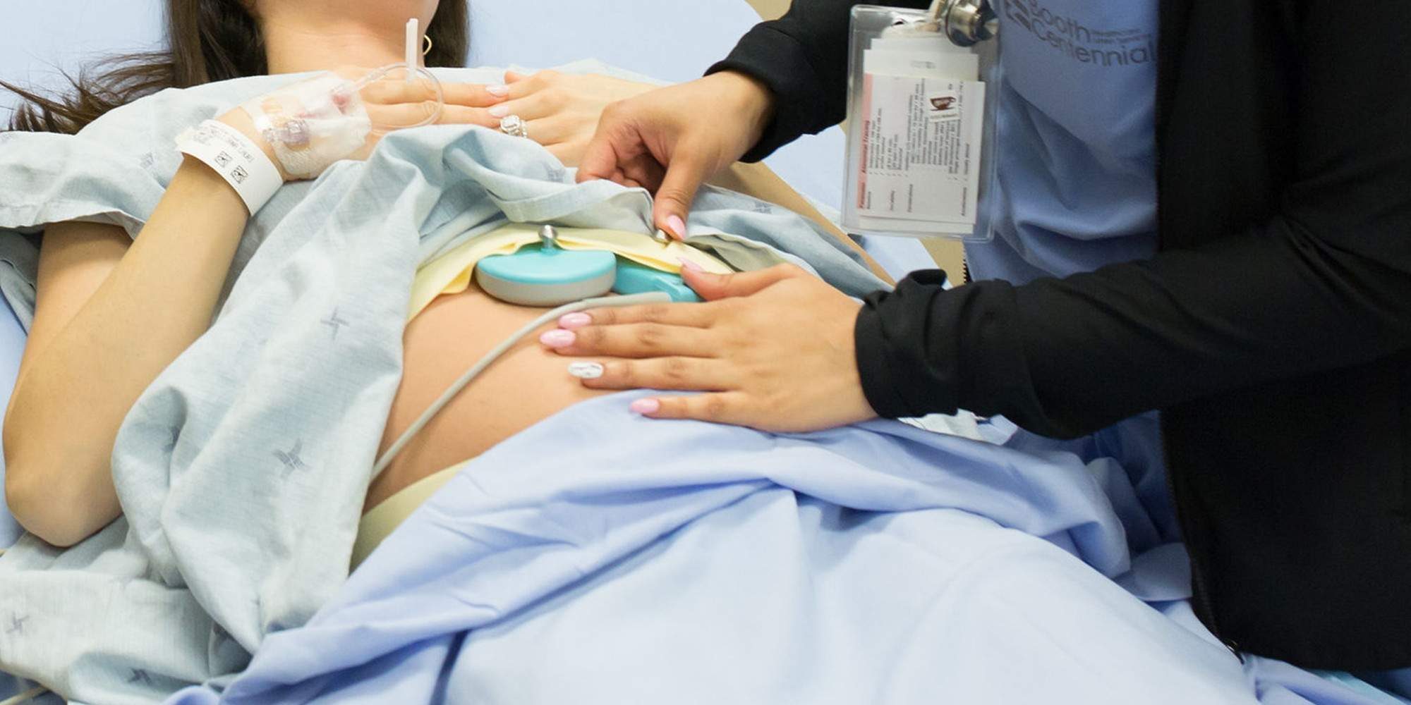 A nurse examines a pregnant woman's belly