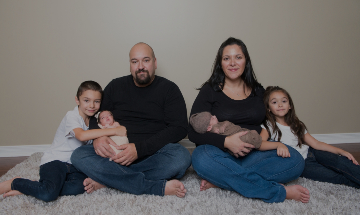 Lisa, her husband, and four children sit on the floor for a portrait.