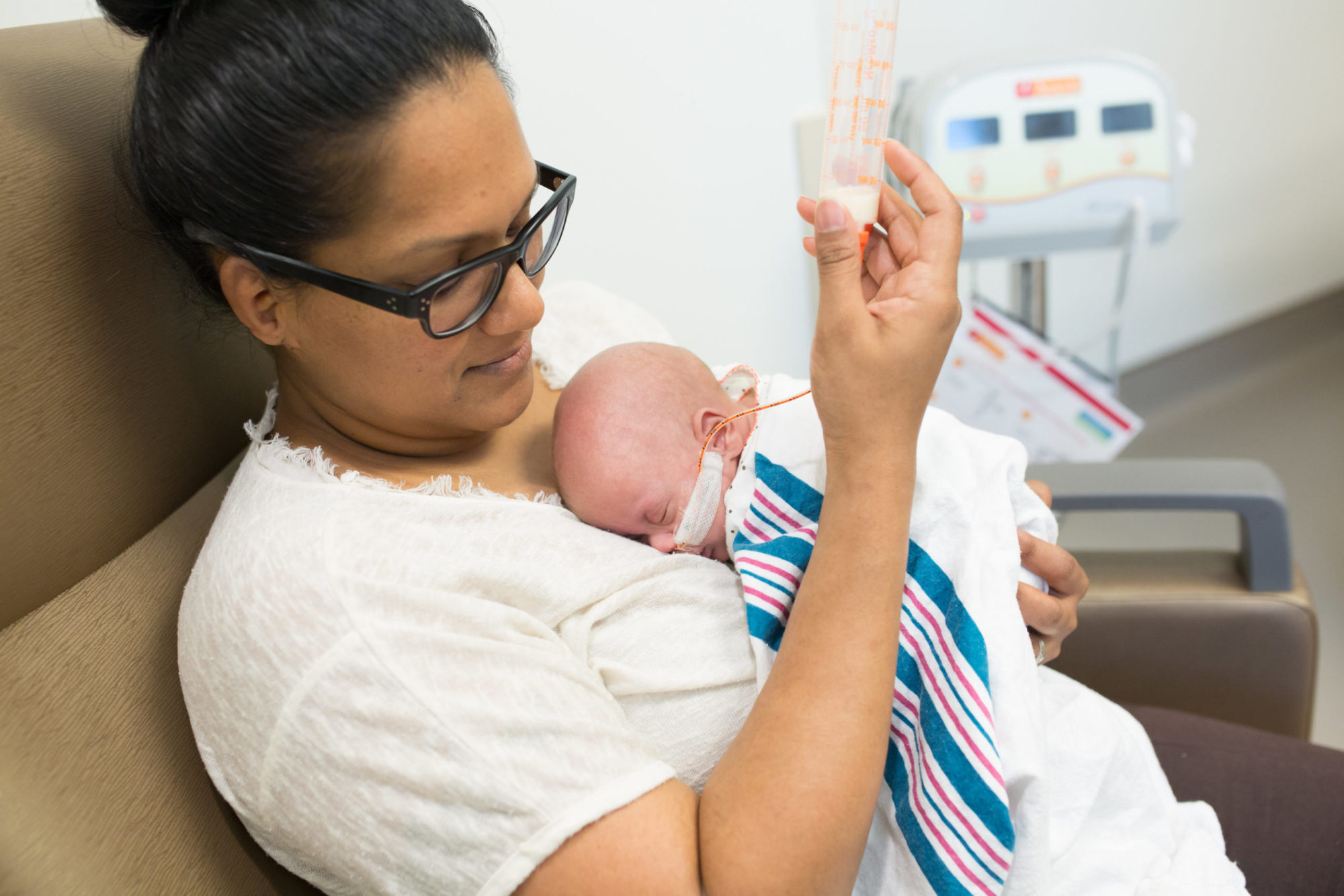 A mother feeds her premature baby