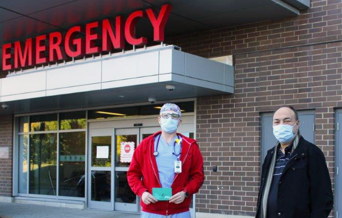 Tony and Fabio stand outside the Emergency Department with Fabio's Gift of Gratitude Card