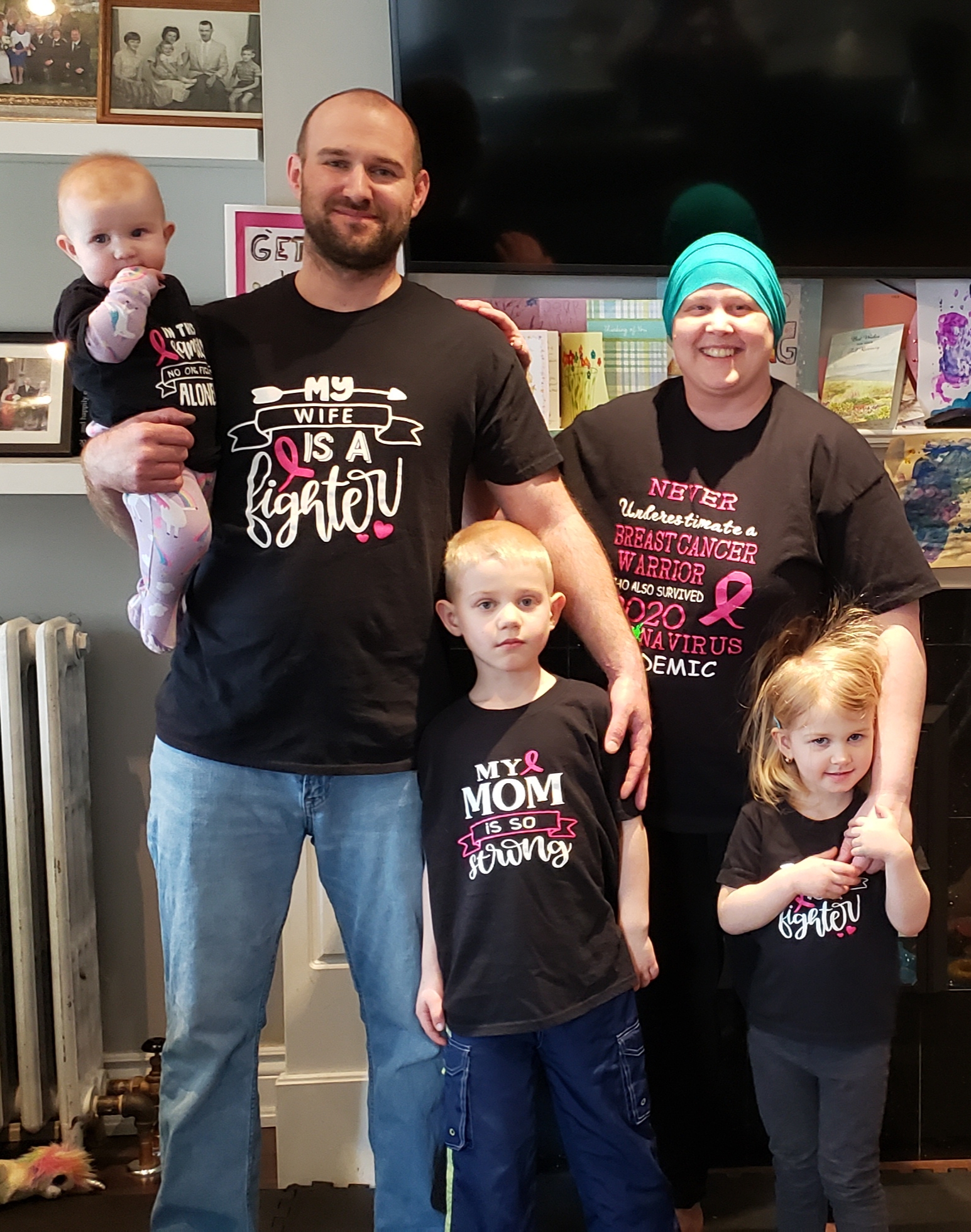 A photo of Danielle wearing a scarf around her head, with her husband and three children. All five are smiling at the camera.