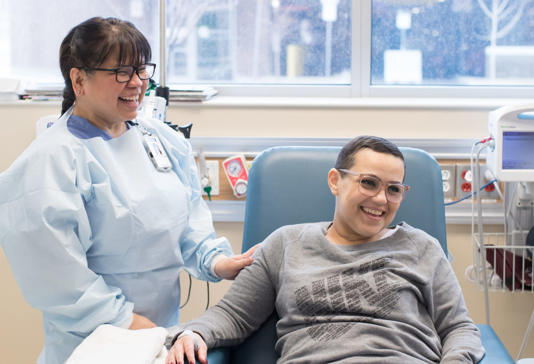 In our Cancer Care Clinic, a nurse and a patient laugh together.