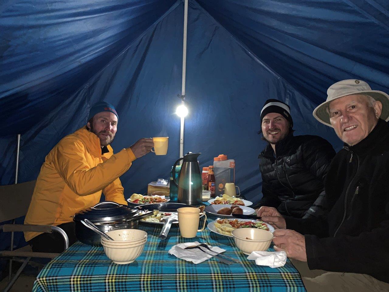 Martin and his sons having dinner in their tent during their climb of Mount Kilimanjaro